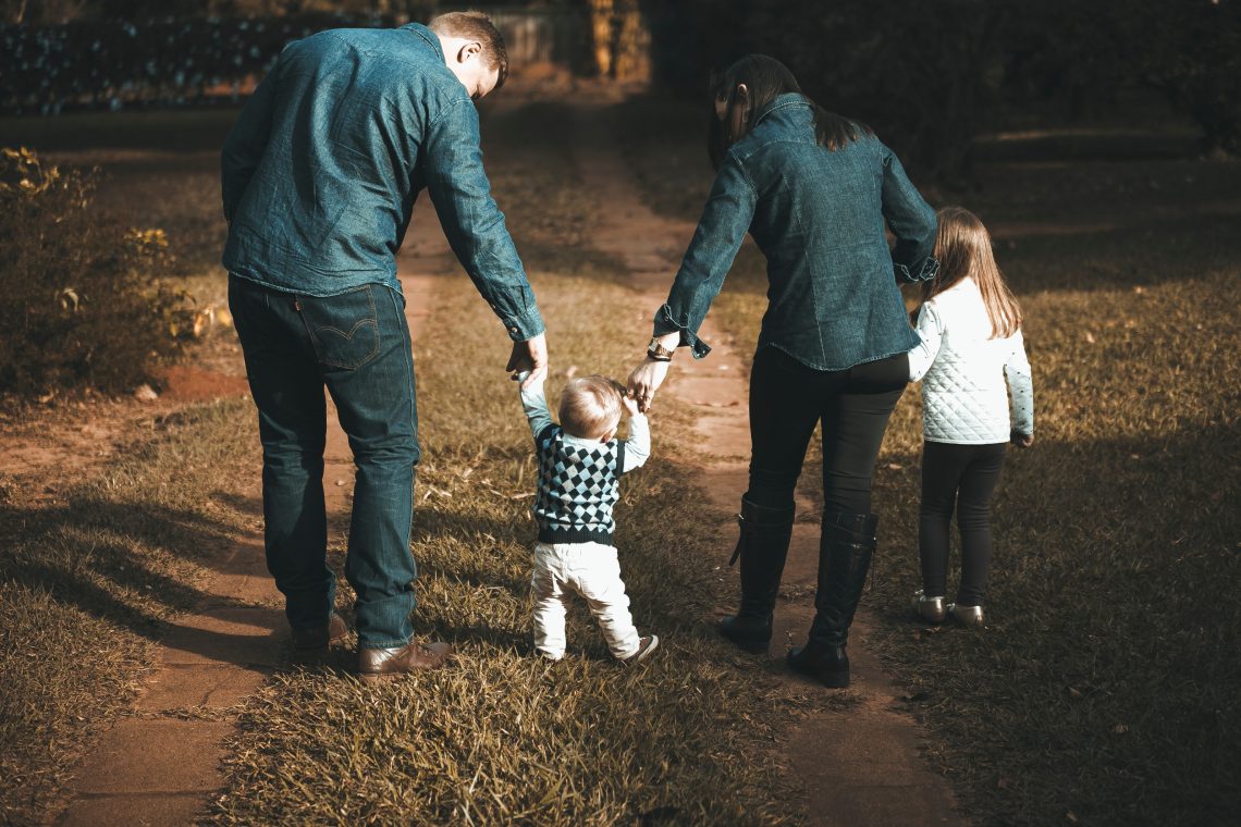 Image of a young family walking down a dirt road.