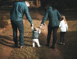 Image of a young family walking down a dirt road.